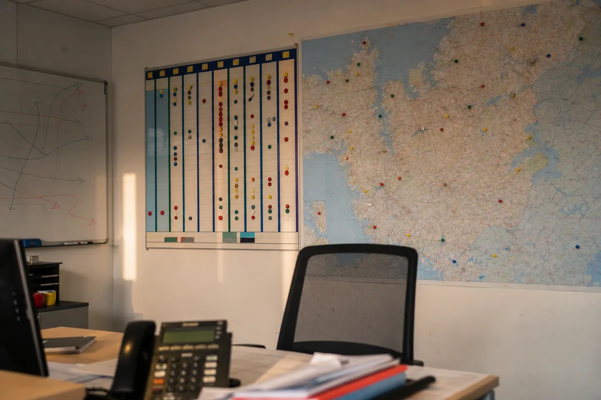 Cartographie logistique et planning d’exploitation affichés dans un bureau de transporteur